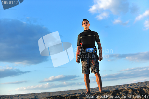 Image of Portrait of a young  kitsurf  man at beach on sunset