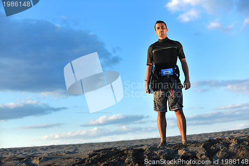 Image of Portrait of a young  kitsurf  man at beach on sunset