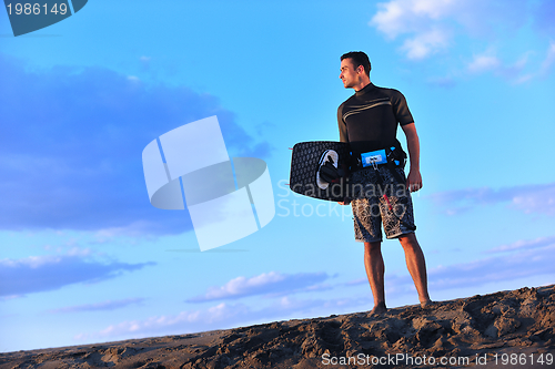 Image of Portrait of a young  kitsurf  man at beach on sunset