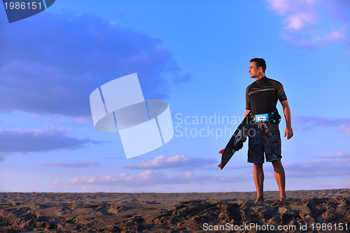 Image of Portrait of a young  kitsurf  man at beach on sunset