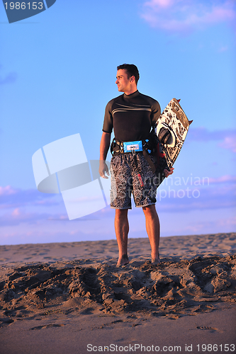 Image of Portrait of a young  kitsurf  man at beach on sunset