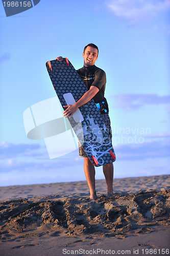 Image of Portrait of a young  kitsurf  man at beach on sunset