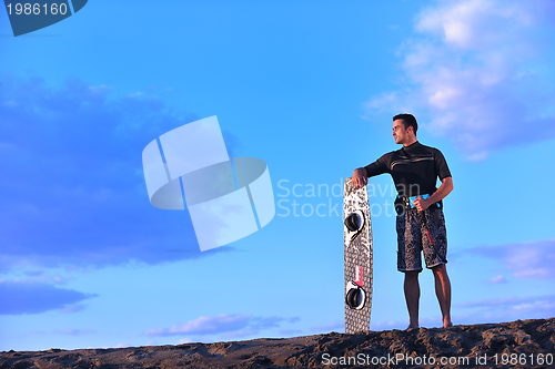 Image of Portrait of a young  kitsurf  man at beach on sunset