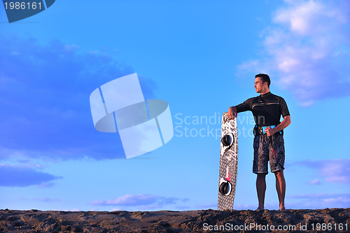 Image of Portrait of a young  kitsurf  man at beach on sunset