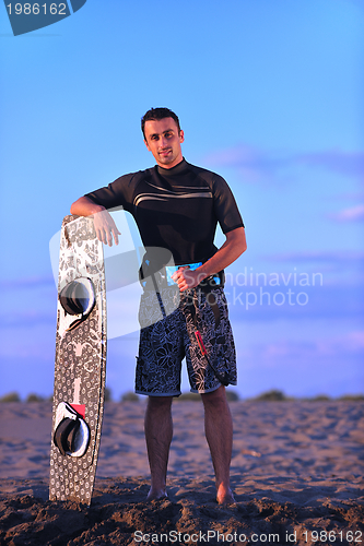 Image of Portrait of a young  kitsurf  man at beach on sunset