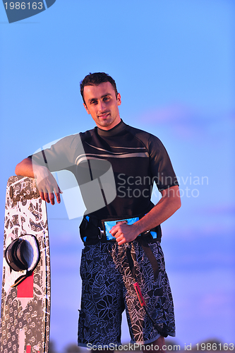 Image of Portrait of a young  kitsurf  man at beach on sunset