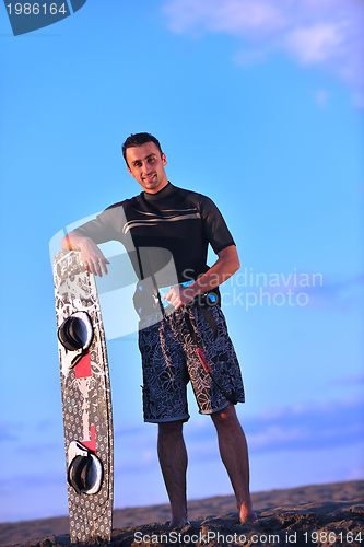 Image of Portrait of a young  kitsurf  man at beach on sunset