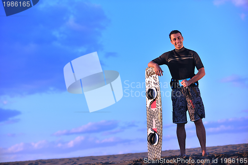 Image of Portrait of a young  kitsurf  man at beach on sunset