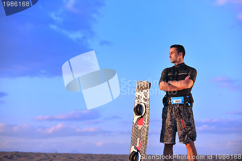 Image of Portrait of a young  kitsurf  man at beach on sunset