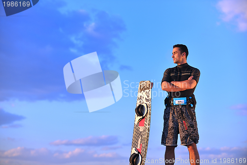 Image of Portrait of a young  kitsurf  man at beach on sunset