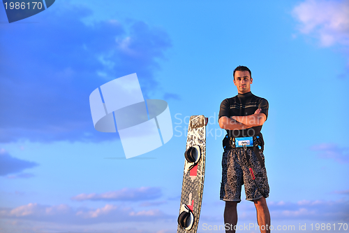 Image of Portrait of a young  kitsurf  man at beach on sunset