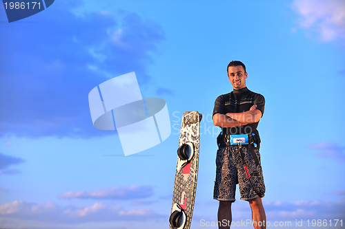 Image of Portrait of a young  kitsurf  man at beach on sunset