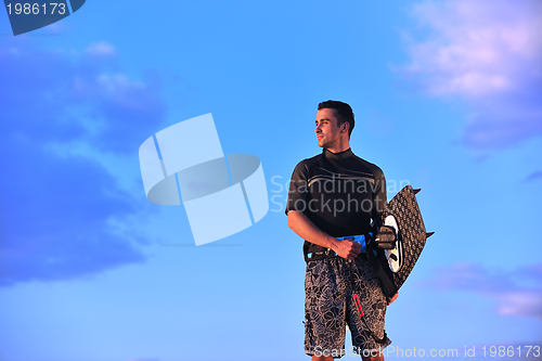 Image of Portrait of a young  kitsurf  man at beach on sunset