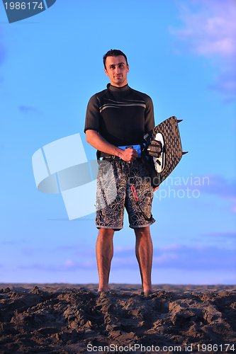 Image of Portrait of a young  kitsurf  man at beach on sunset