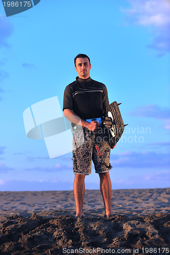 Image of Portrait of a young  kitsurf  man at beach on sunset