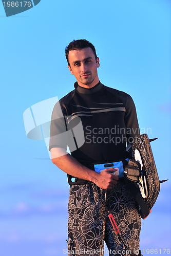 Image of Portrait of a young  kitsurf  man at beach on sunset