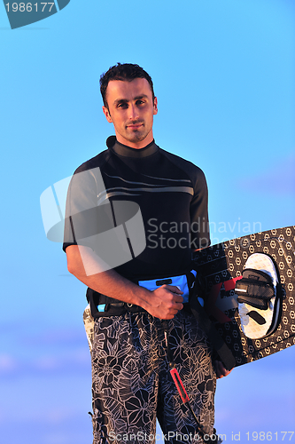 Image of Portrait of a young  kitsurf  man at beach on sunset