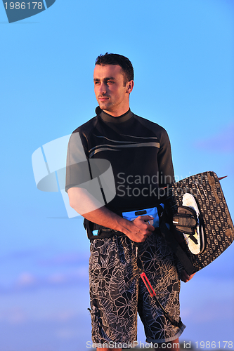 Image of Portrait of a young  kitsurf  man at beach on sunset
