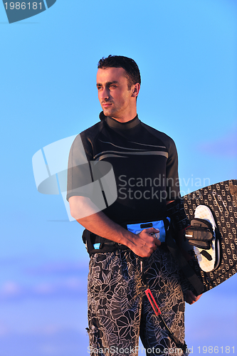 Image of Portrait of a young  kitsurf  man at beach on sunset