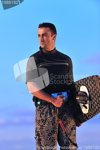 Image of Portrait of a young  kitsurf  man at beach on sunset