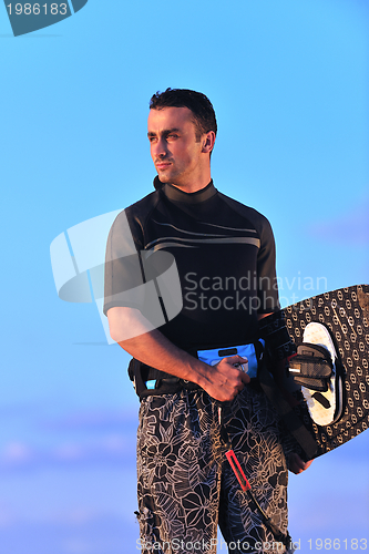 Image of Portrait of a young  kitsurf  man at beach on sunset