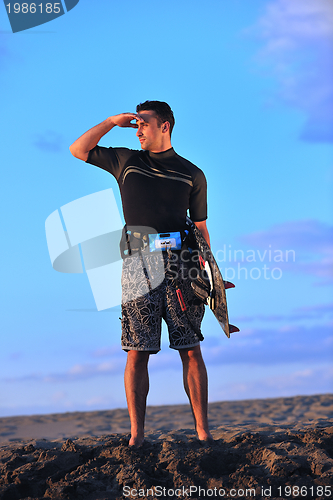 Image of Portrait of a young  kitsurf  man at beach on sunset