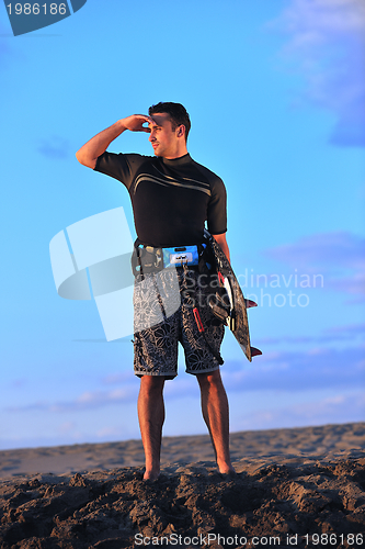 Image of Portrait of a young  kitsurf  man at beach on sunset