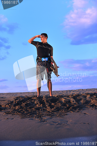 Image of Portrait of a young  kitsurf  man at beach on sunset