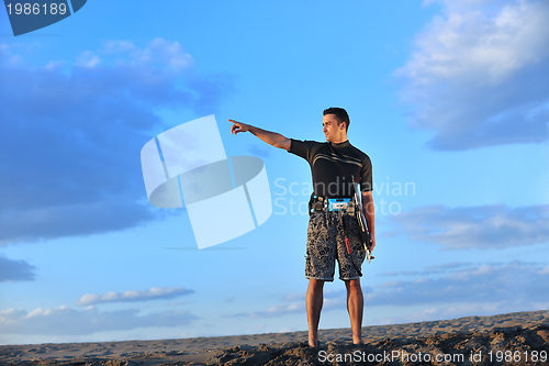 Image of Portrait of a young  kitsurf  man at beach on sunset