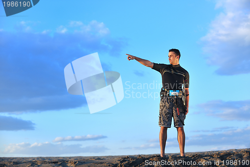 Image of Portrait of a young  kitsurf  man at beach on sunset