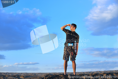 Image of Portrait of a young  kitsurf  man at beach on sunset