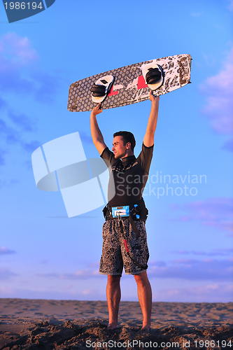 Image of Portrait of a young  kitsurf  man at beach on sunset