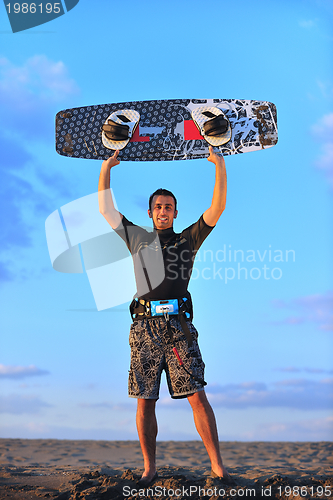 Image of Portrait of a young  kitsurf  man at beach on sunset