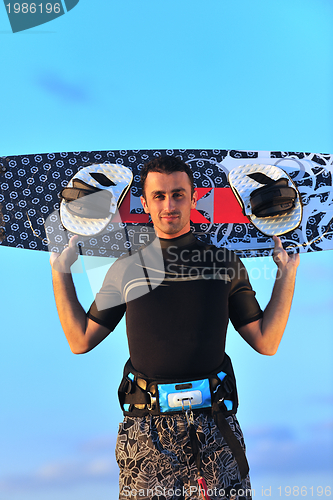 Image of Portrait of a young  kitsurf  man at beach on sunset