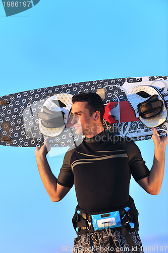 Image of Portrait of a young  kitsurf  man at beach on sunset