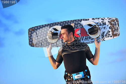 Image of Portrait of a young  kitsurf  man at beach on sunset