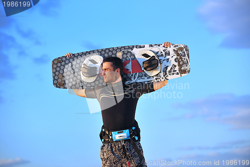 Image of Portrait of a young  kitsurf  man at beach on sunset