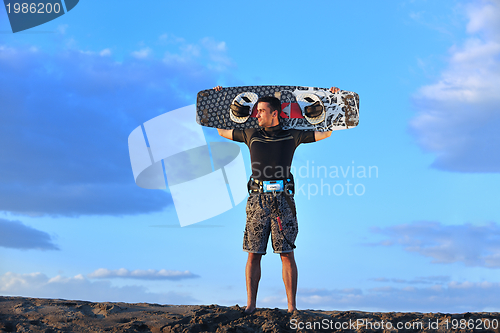 Image of Portrait of a young  kitsurf  man at beach on sunset