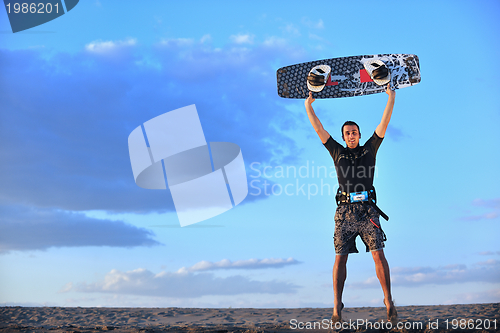 Image of Portrait of a young  kitsurf  man at beach on sunset