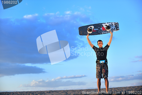Image of Portrait of a young  kitsurf  man at beach on sunset
