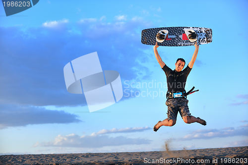 Image of Portrait of a young  kitsurf  man at beach on sunset