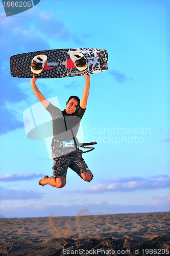 Image of Portrait of a young  kitsurf  man at beach on sunset