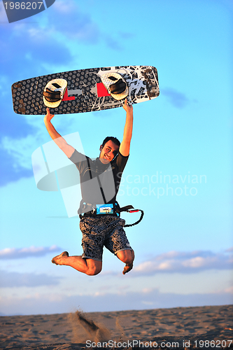 Image of Portrait of a young  kitsurf  man at beach on sunset