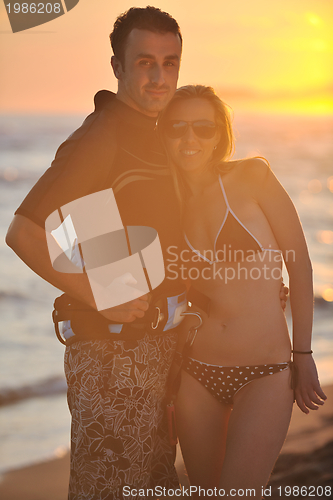 Image of surf couple posing at beach on sunset