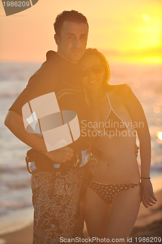 Image of surf couple posing at beach on sunset