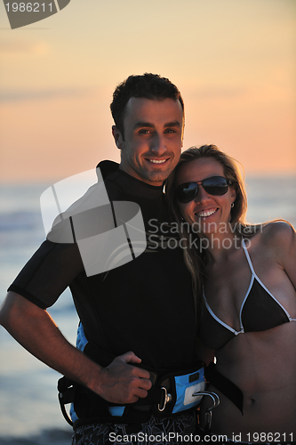 Image of surf couple posing at beach on sunset
