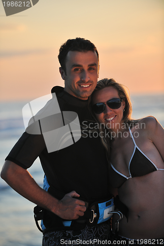 Image of surf couple posing at beach on sunset