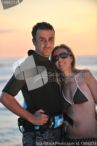 Image of surf couple posing at beach on sunset