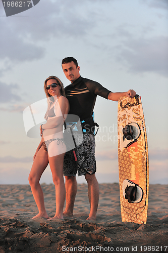 Image of surf couple posing at beach on sunset