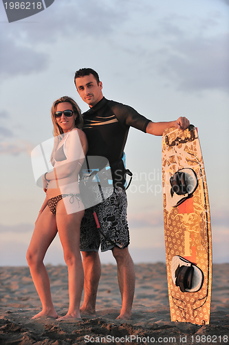 Image of surf couple posing at beach on sunset